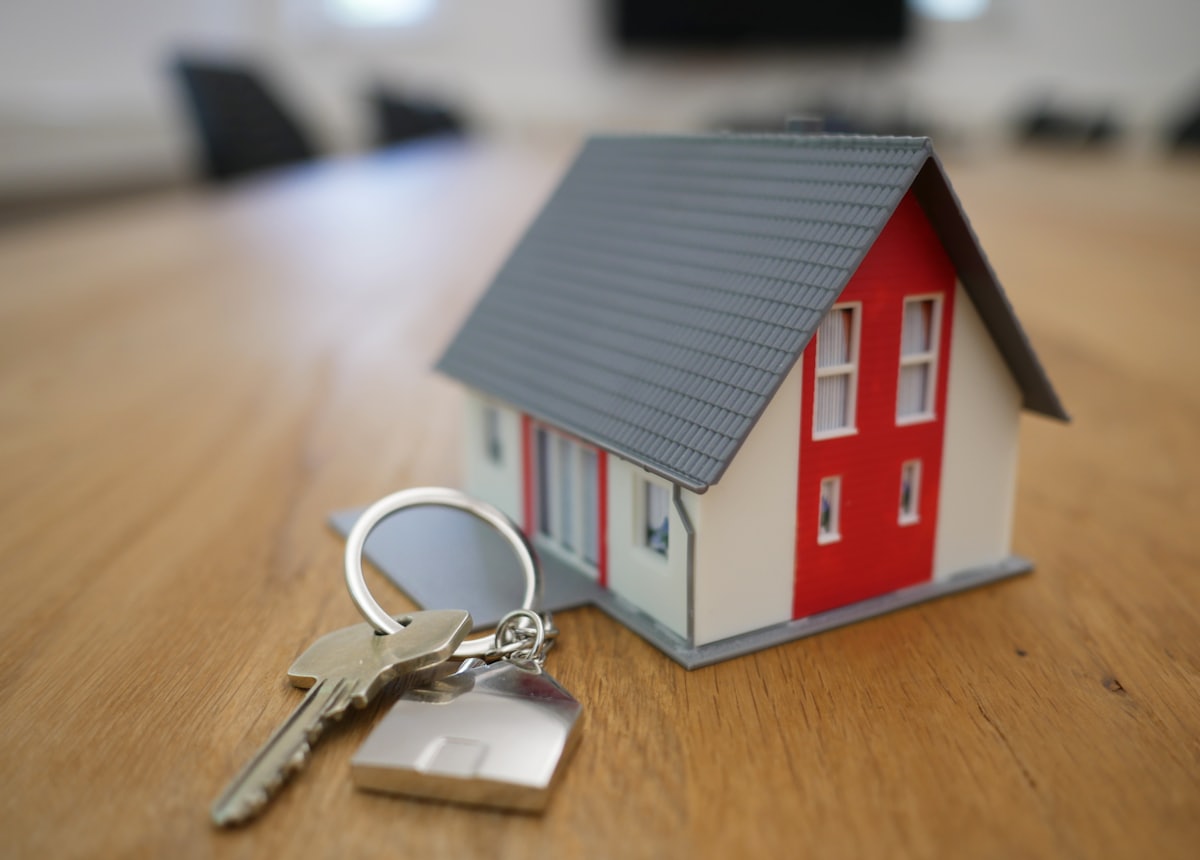 A set of keys beside a model house